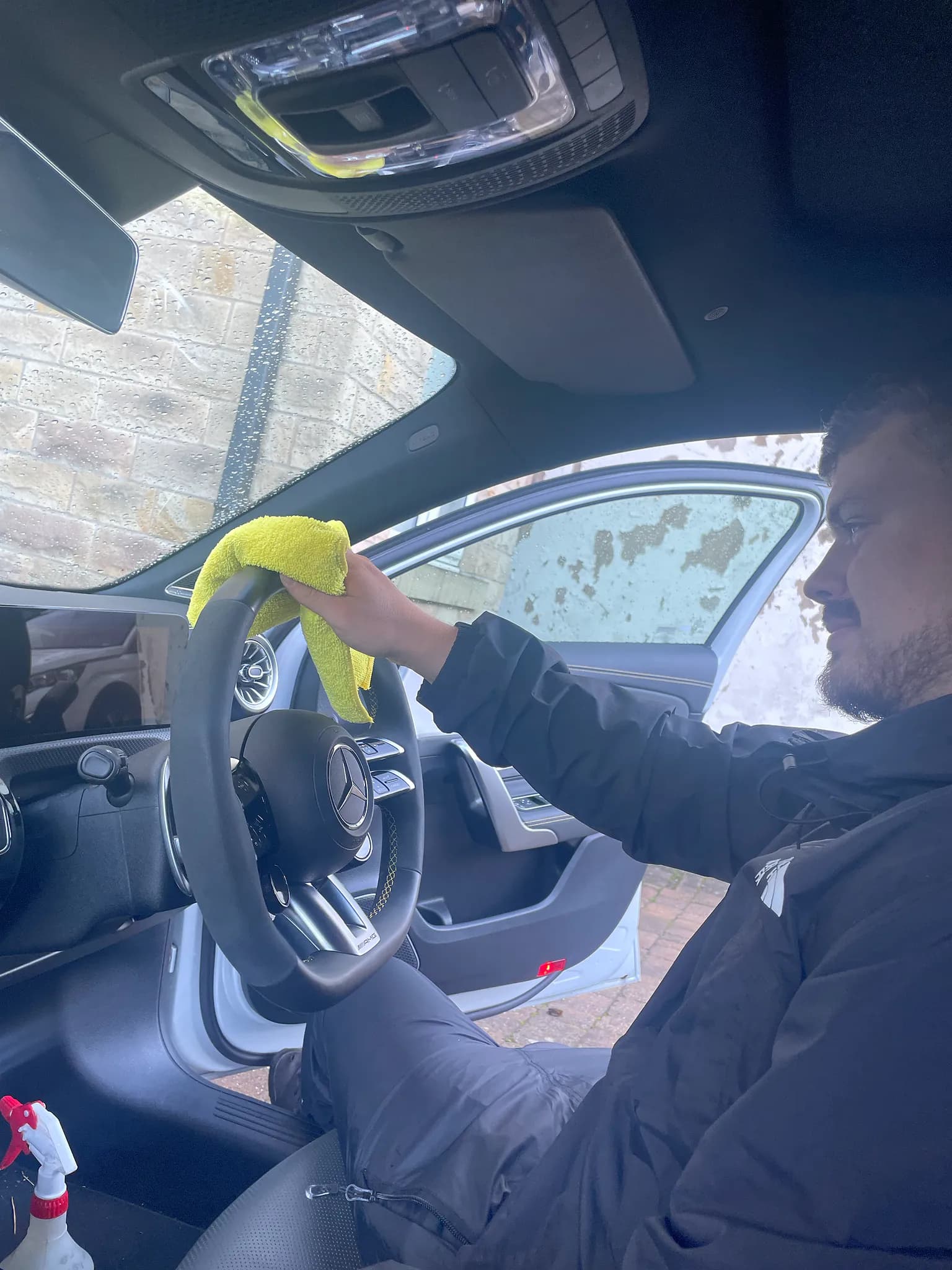 Cameron Duffy of DRC Car Care wiping down a Mercedes steering wheel with a microfibre cloth