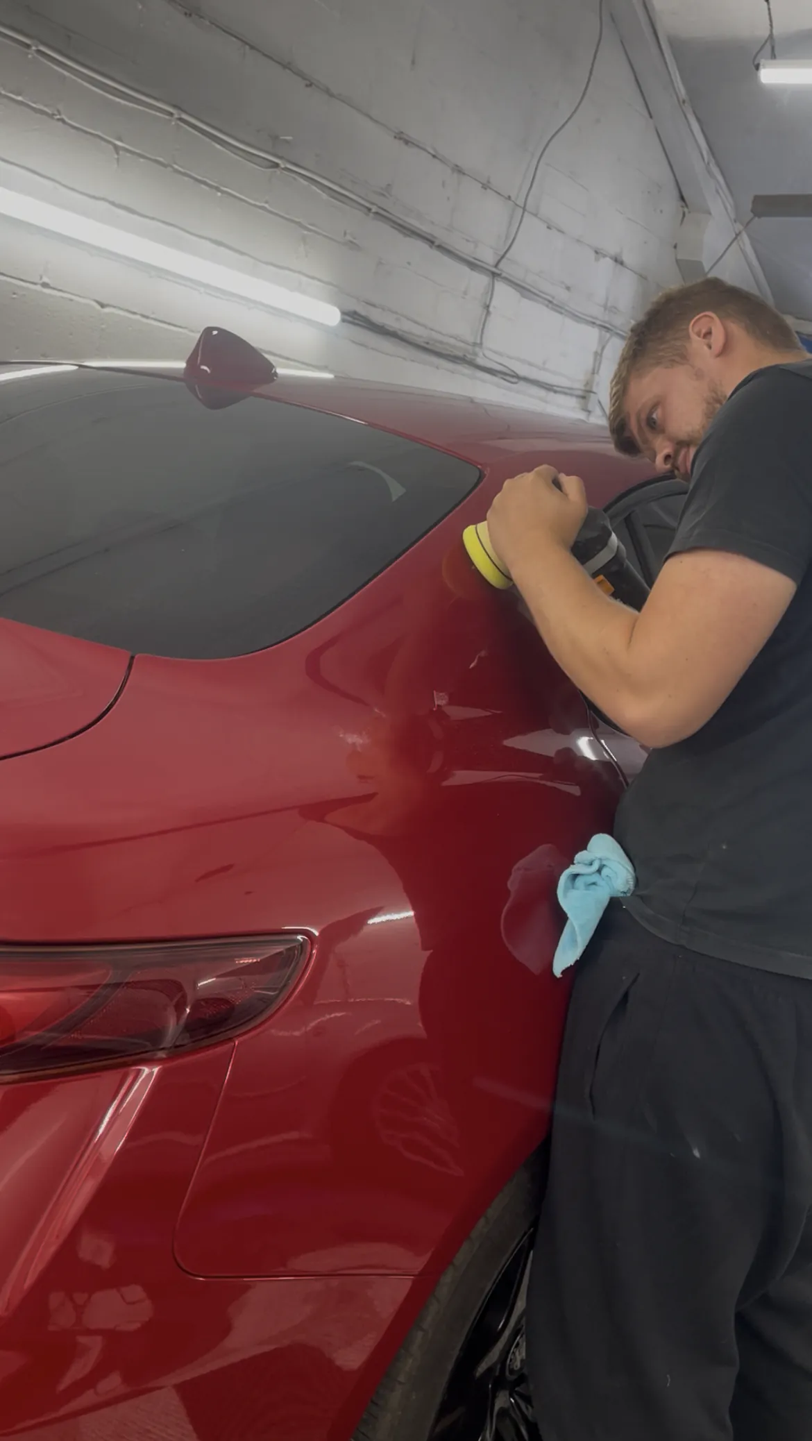 Cameron Duffy of DRC Car Care machine polishing a red car at the DRC Car Care unit